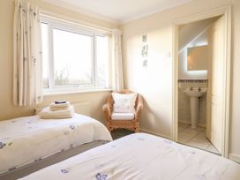 A bedroom with twin beds and a bathroom sink at Llwyn Derw in Talybont