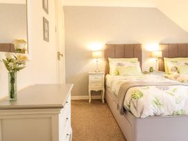 A bedroom with two beds and a dresser at Llwyn Derw Talybont