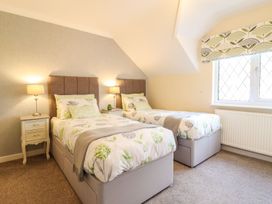 A bedroom with two beds and a nightstand at Llwyn Derw in Talybont