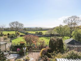 A garden with trees and seating area at Llwyn Derw Talybont