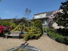A garden with a bench and various plants at Llwyn Derw in Talybont