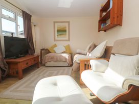 A living room with a television and sofa at Chalet 225 Tregolds near St Merryn