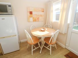A dining room with a table and chairs at Chalet 225 Tregolds near St Merryn
