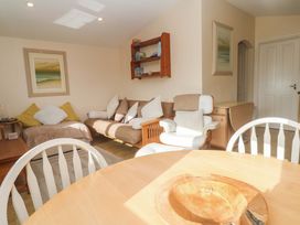 A living room with a sofa and table at Chalet 225 Tregolds near St Merryn