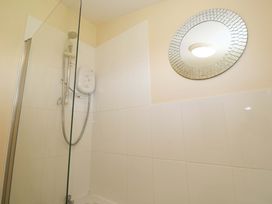 A shower area with a circular mirror at Chalet 225 Tregolds near St Merryn