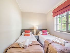 A bedroom with two single beds and a lamp at Ailsa Craig Spa, Dailly