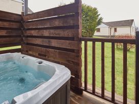 A hot tub on a deck with wooden fencing at Ailsa Craig Spa Dailly