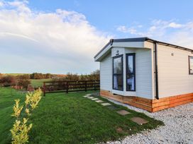 A cabin with a pathway and grass at Rosefinch Cabin in Scarborough