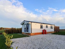 A cabin with windows and gas bottles at Rosefinch Cabin in Scarborough