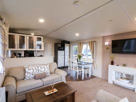 A living room with seating and a dining area at Rosefinch Cabin in Scarborough