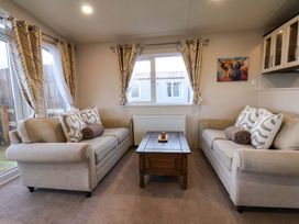 A living room with sofas and a coffee table at Rosefinch Cabin in Scarborough