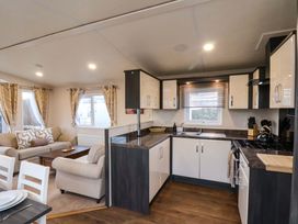 A kitchen with cabinets and a dining area at Rosefinch Cabin in Scarborough