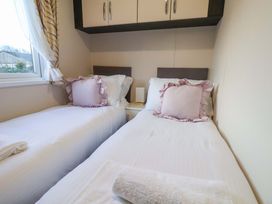 A bedroom with two beds and a window at Rosefinch Cabin Scarborough