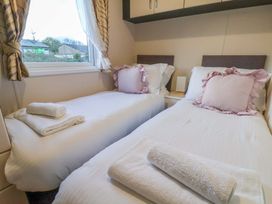 A bedroom with two beds and a window at Rosefinch Cabin Scarborough