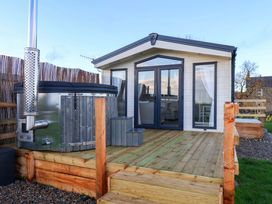 An outdoor area with a hot tub and cabin at Rosefinch Cabin in Scarborough