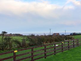 A landscape view featuring a fence and distant houses at Rosefinch Cabin in Scarborough