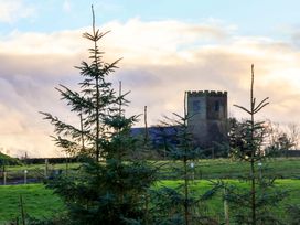 A view of a church tower among trees in a field at Rosefinch Cabin Scarborough