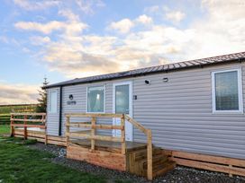 An outdoor view of a cabin with wooden steps and a grassy area at Swift Cabin in Scarborough