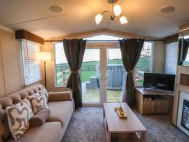 A living room with a sofa and television at Swift Cabin in Scarborough