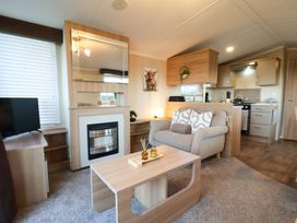 A living room with a sofa and coffee table at Swift Cabin in Scarborough