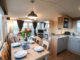 A dining room with a table set and a sofa at Swift Cabin in Scarborough