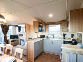 A kitchen with appliances and a dining table at Swift Cabin in Scarborough