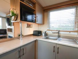 A kitchen with a sink and microwave at Swift Cabin in Scarborough