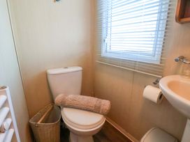 A bathroom with a toilet and sink at Swift Cabin Scarborough
