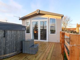 An outdoor area with a hot tub and entrance doors at Swift Cabin in Scarborough