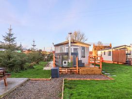 A cabin with outdoor seating and grass area at Swift Cabin Scarborough