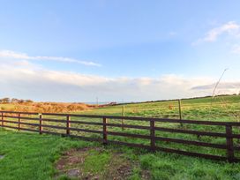 A view of a fenced grassland under a partly cloudy sky at Swift Cabin in Scarborough