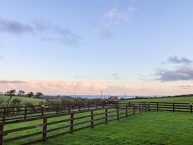 An open field with a wooden fence and distant hills at Swift Cabin in Scarborough