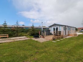 A cabin with a deck and hot tub at Swift Cabin Staintondale near Scarborough