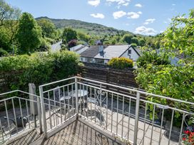 An outdoor area with a balcony and table at Oaks Lodge Cottage in Ambleside