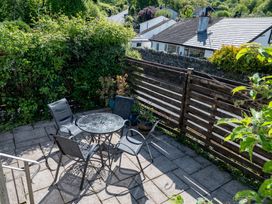 A garden with a table and chairs at Oaks Lodge Cottage in Ambleside