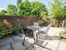 A garden with a table and chairs at Oaks Lodge Cottage Ambleside