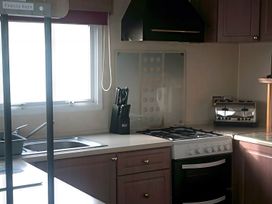 A kitchen with a cooking range, sink, and toaster at Coopers Beach Holiday Park - Holiday Accommodation 3999 Mersea Island