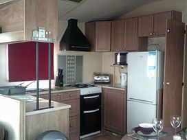A kitchen with appliances and cabinets at Coopers Beach Holiday Park - Holiday Accommodation 3999 Mersea Island