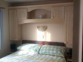 A bedroom with a bed and cupboard at Coopers Beach Holiday Park - Holiday Accommodation 3999 Mersea Island