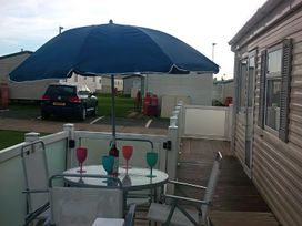An outdoor patio with a table and chairs at Coopers Beach Holiday Park - Holiday Accommodation 3999 Mersea Island