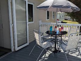 A deck with a table and chairs at Coopers Beach Holiday Park - Holiday Accommodation 6404 Mersea Island