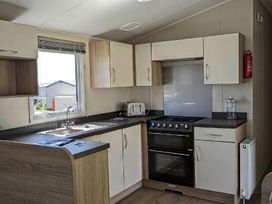 A kitchen with oven, sink, cabinets and toaster at Coopers Beach Holiday Park - Holiday Accommodation 6404 Mersea Island