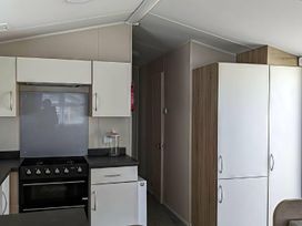 A kitchen with cabinets and an oven at Coopers Beach Holiday Park - Holiday Accommodation 6404 Mersea Island