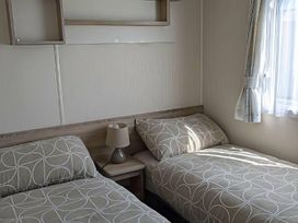 A bedroom with two beds and a side table at Coopers Beach Holiday Park - Holiday Accommodation 6404 Mersea Island