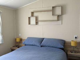 A bedroom with a bed and a shelf at Coopers Beach Holiday Park - Holiday Accommodation 6404, Mersea Island