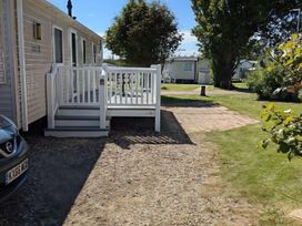 An outdoor area with a deck and car at Coopers Beach Holiday Park - Holiday Accommodation 6404 Mersea Island