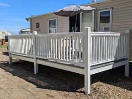 An outdoor patio with a deck and railing at Coopers Beach Holiday Park - Holiday Accommodation 6404 Mersea Island