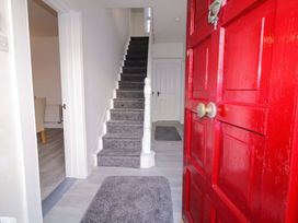 A hallway with a red front door and staircase at San Antonio, Dungloe, County Donegal