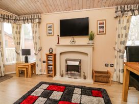A living room with furniture and a fireplace at Kingfisher Lodge in Windermere