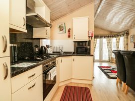 A kitchen with cabinets and appliances at Kingfisher Lodge in Windermere